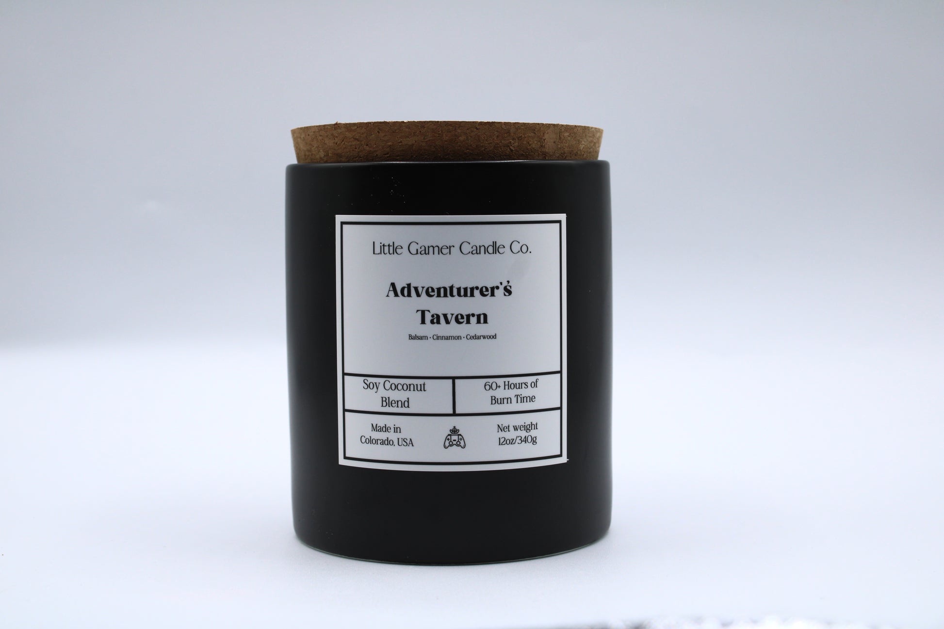 Black candle with a cork lid and label on a white background