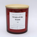 A red glass jar candle with a light wood lid and a white label reading 'Little Gamer Candle Co. Witch of the Waste' on a white background.