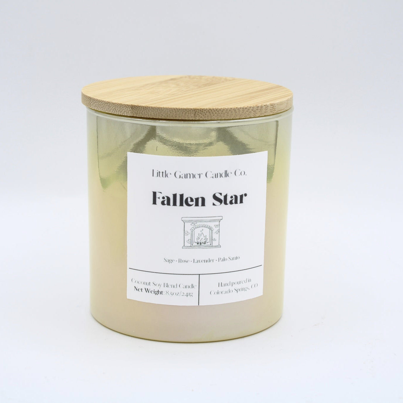 A yellow iridescent jar with a white label reading "Little Gamer Candle Co. Fallen Star" with a light bamboo lid on a white background.